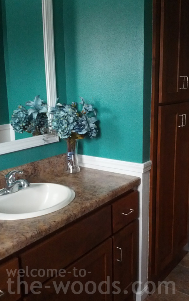 Bathroom redo teal wall color white wainscoting trim framed mirror