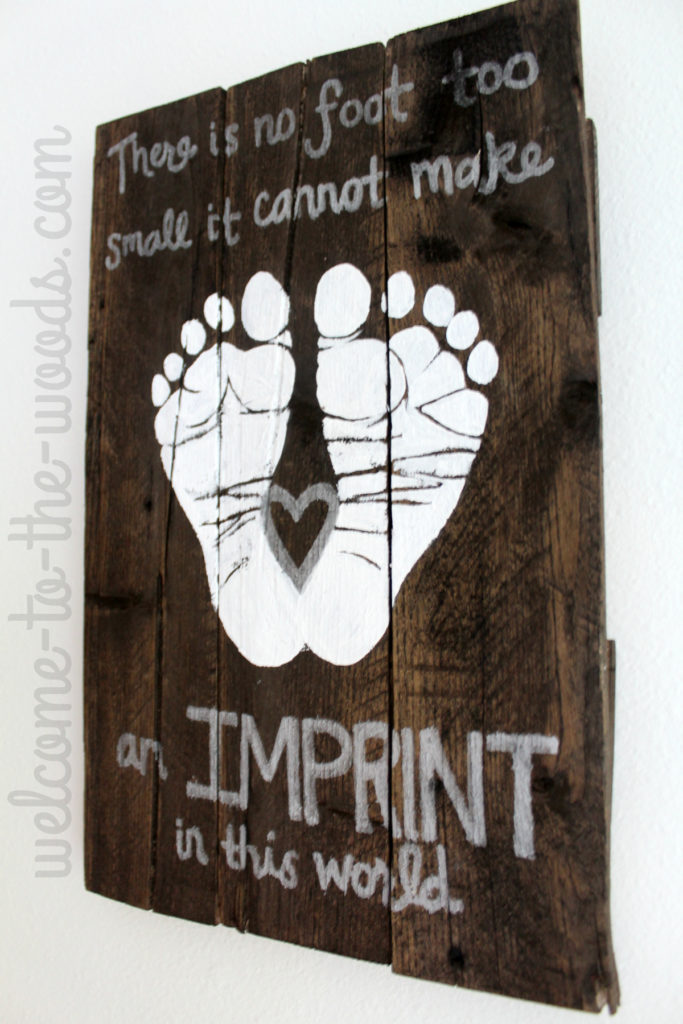 Stained pallet wood sign with baby footprints as nursery decor