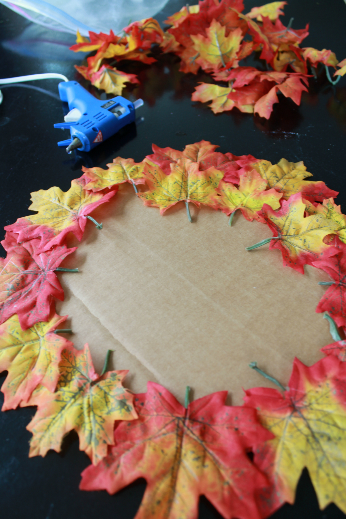 Glue fake leaves onto cardboard circle to make a coaster