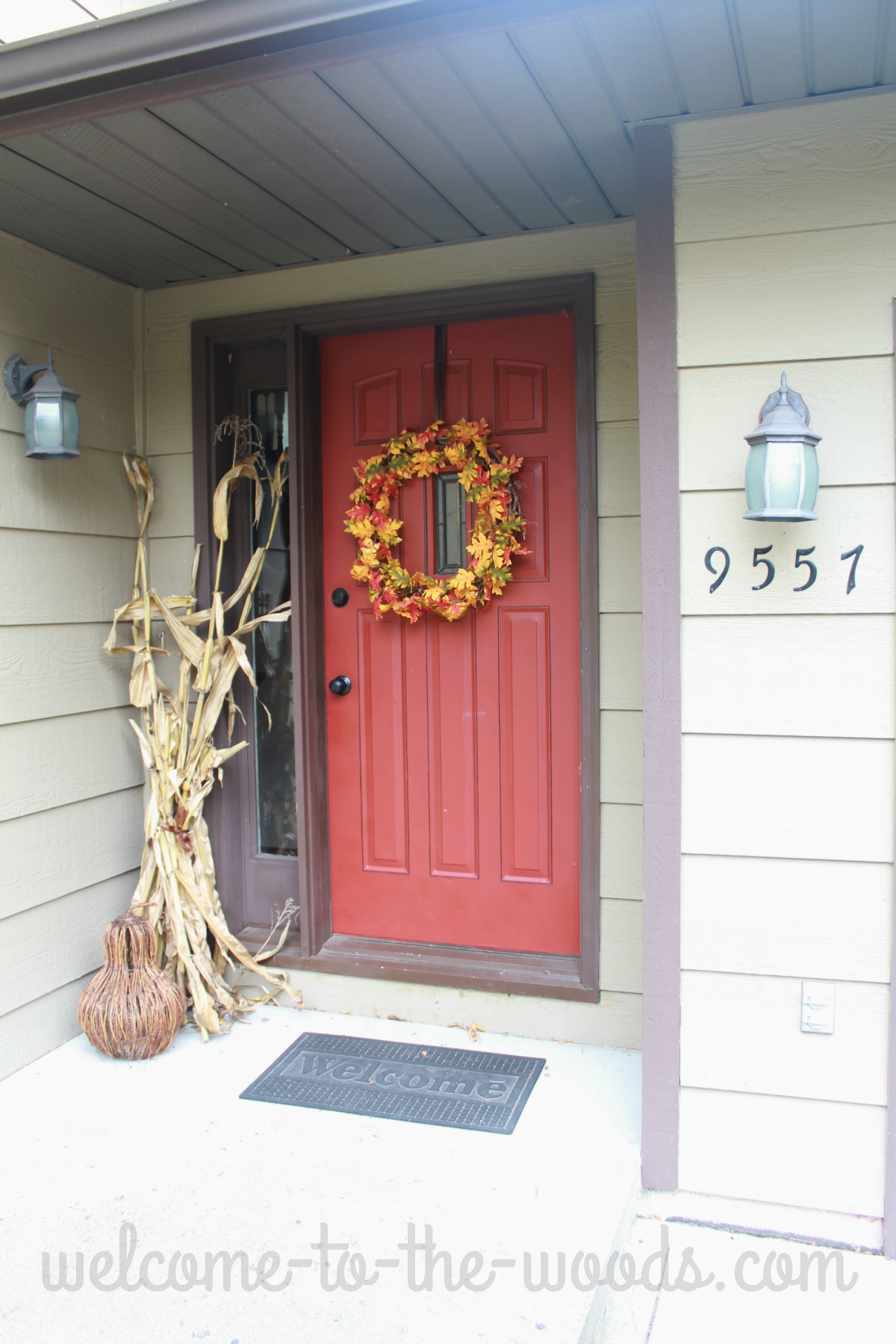 Front entrance autumn decorations. Big wreath of leaves, dry corn stalks, and a grapevine gourd. 