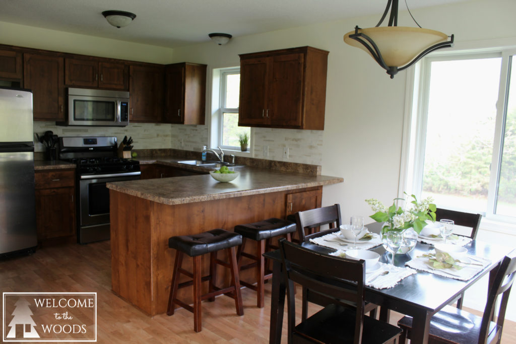 Beautiful bright kitchen design white walls, espresso furniture, stainless steel appliances.