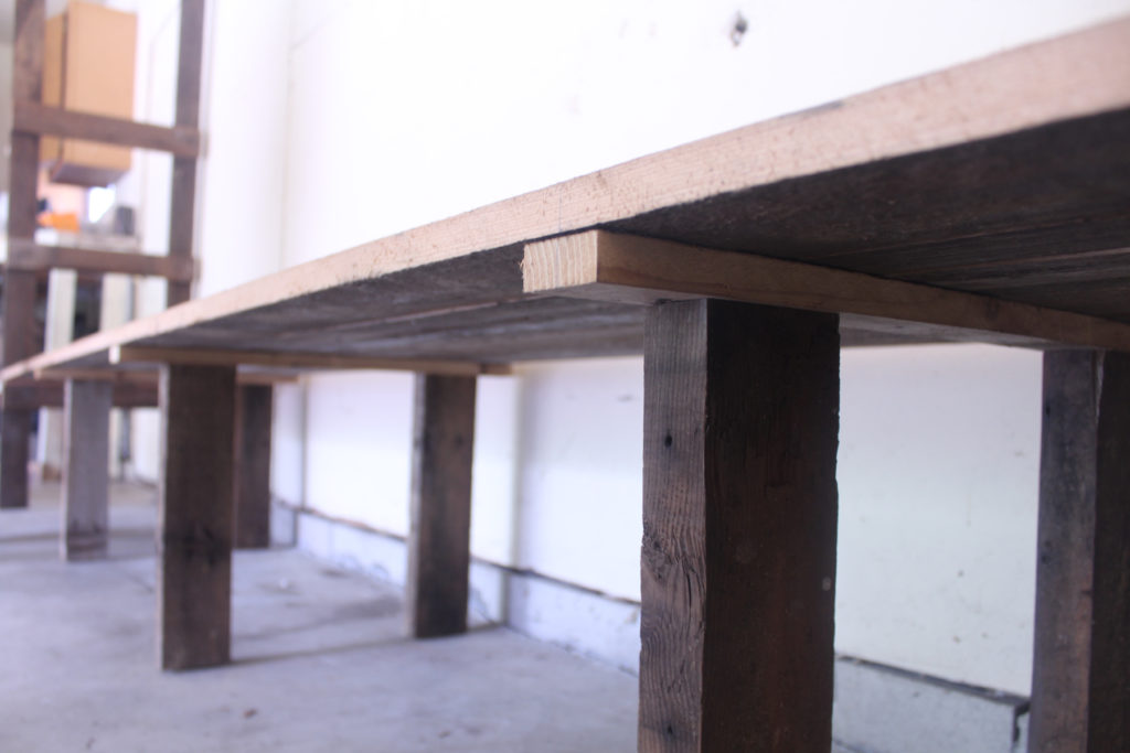 Use reclaimed wood to build garage shelves. This unique design allows for the shelves to be disassembled easily but does not sacrifice on strength.