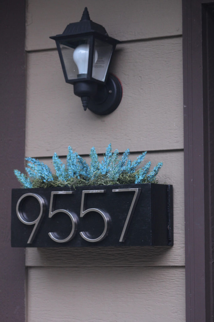 Make a planter box to display seasonal decor for your front entry and your house's address numbers.