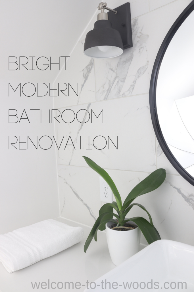 This modern, bright bathroom renovation is sure to inspire! Matte black hardware, circle mirror, teak vanity, marble tile, industrial lighting, quarts countertop, and more!