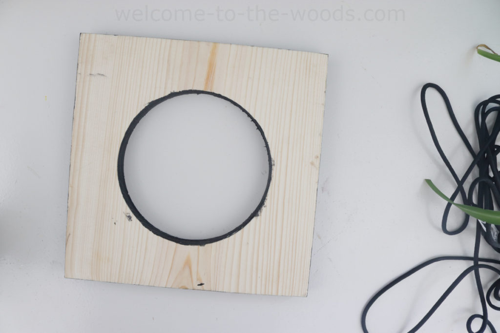 Start with simple wood board to make a modern plant hanger. Cut circle out of the center with a scroll saw or jig saw.