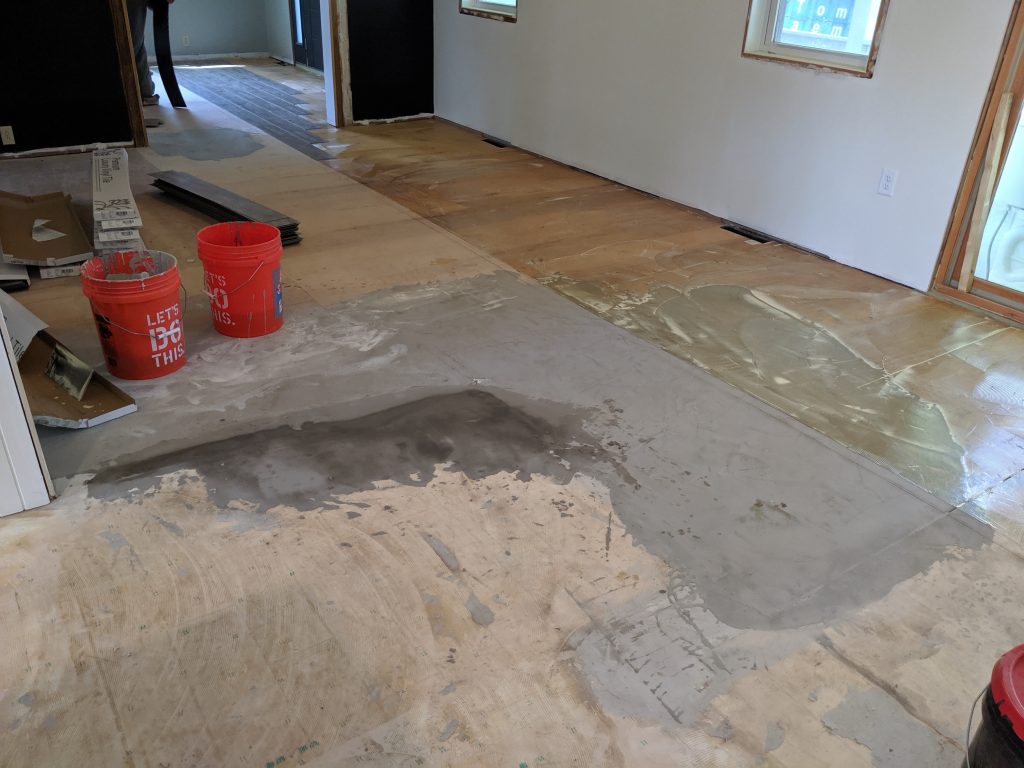 Using a self-leveling pour to improve the old floors in our home because they were all different heights and very bowed.