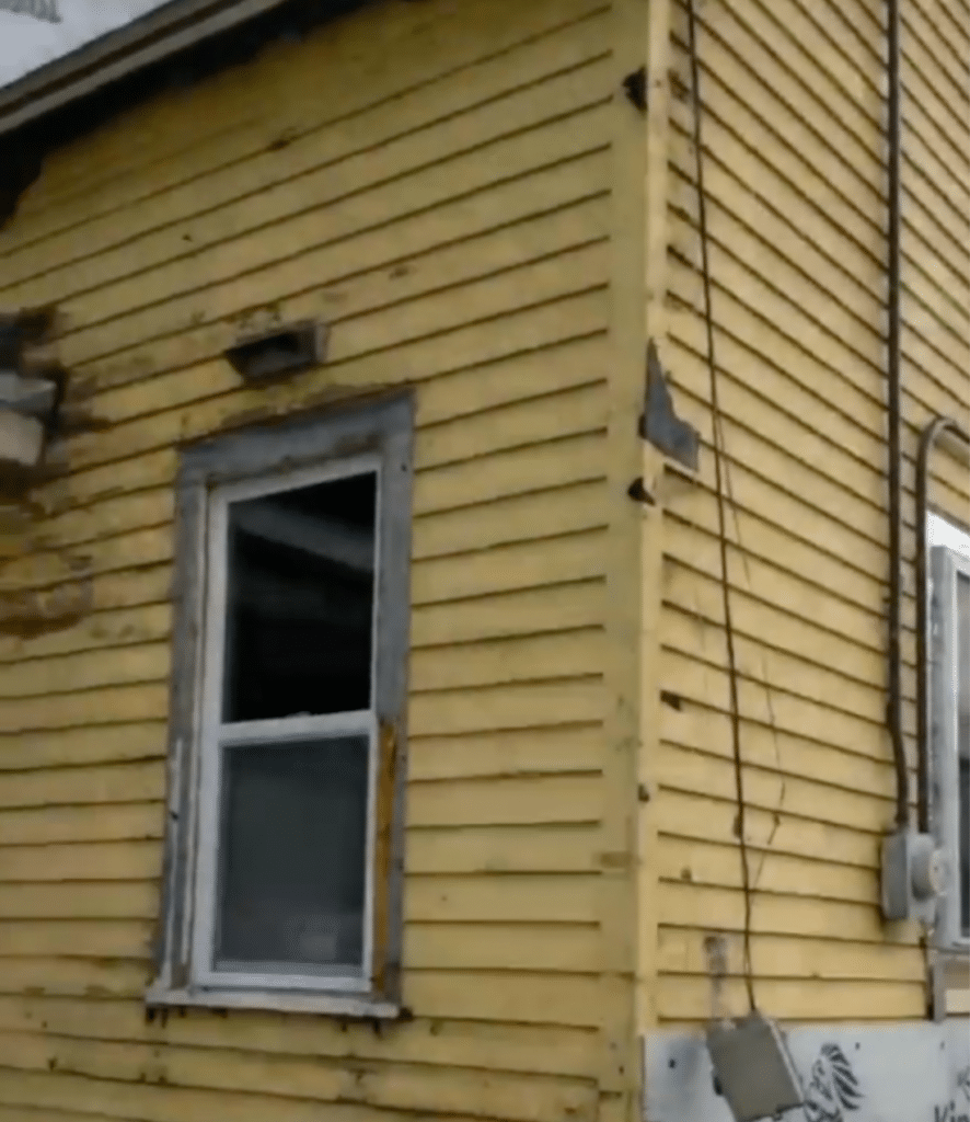 Original wood siding painted yellow in bad condition