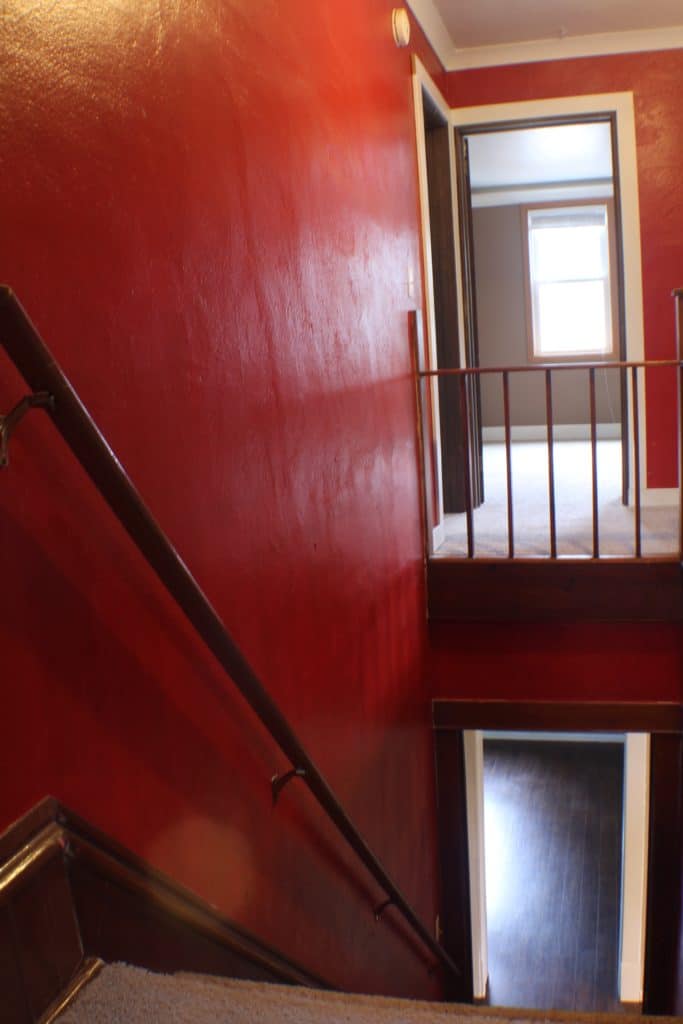 Before photo of stairway with red walls