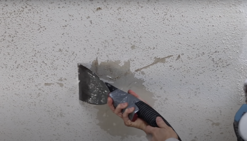 Scraping the popcorn texture off of the ceiling to begin the bedroom makeover