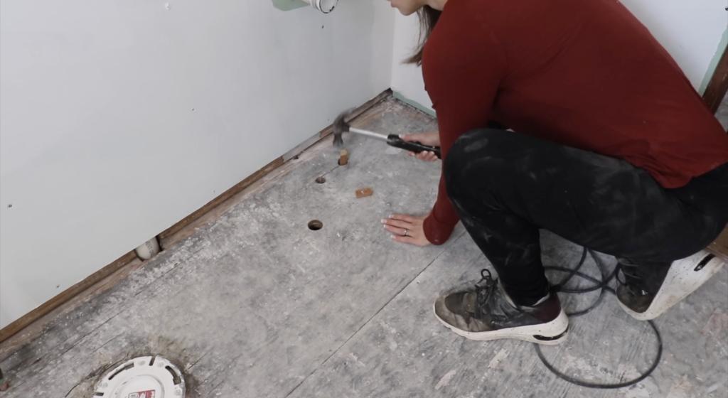 hammering blocks of wood into the holes in the floor